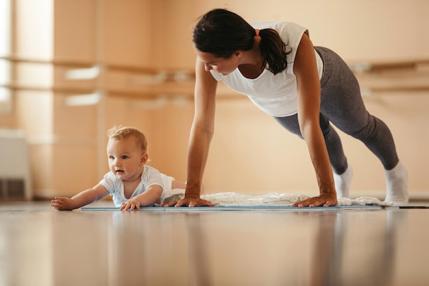 Mom doing squats while holding baby