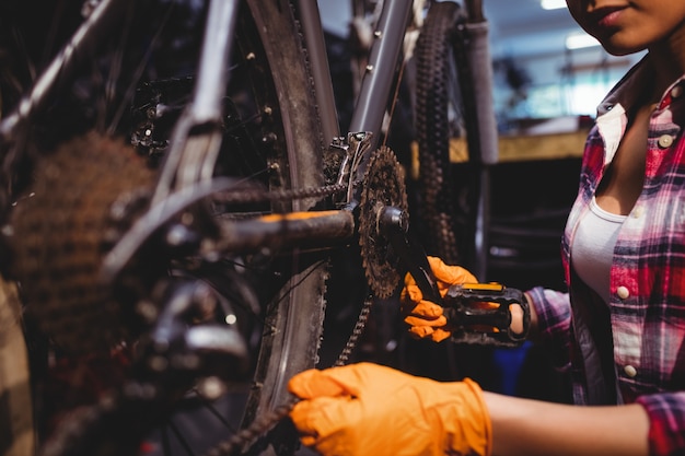 Close-up of hands checking bike chain and tires
