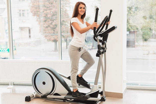 Woman using elliptical machine for heart health