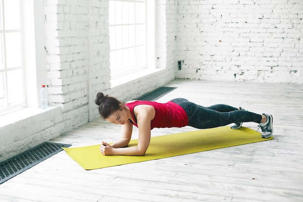 Person holding a plank on a yoga mat
