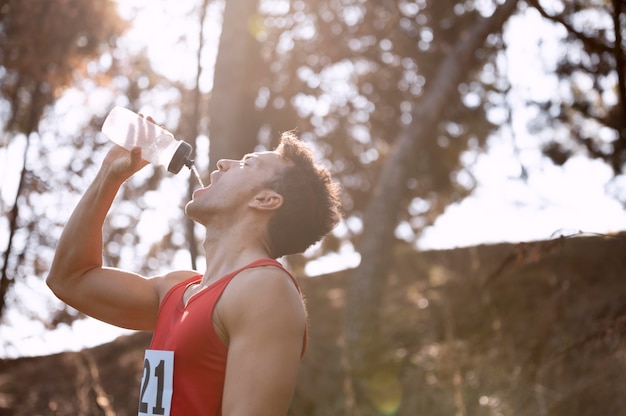 Runner drinking water and eating a balanced meal