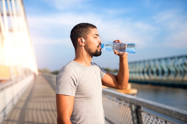 Glass of water with lemon and a water bottle