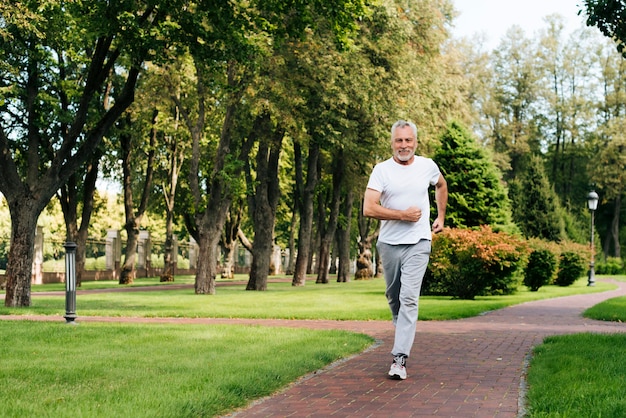 Man jogging in park with heart rate monitor