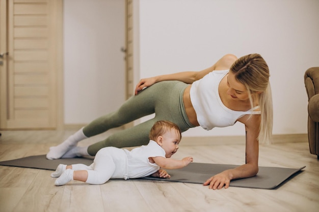 New mom using resistance bands while baby plays nearby