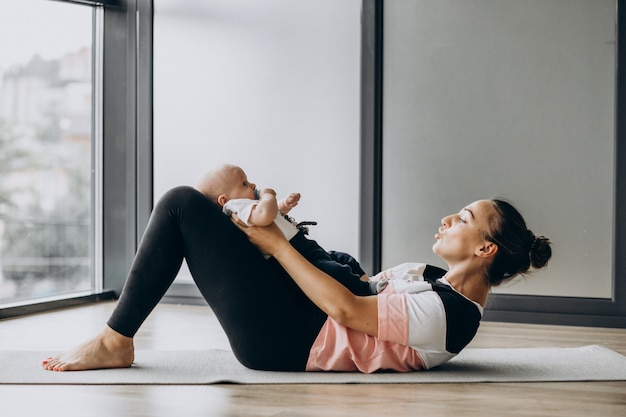 New mom stretching shoulders during breastfeeding
