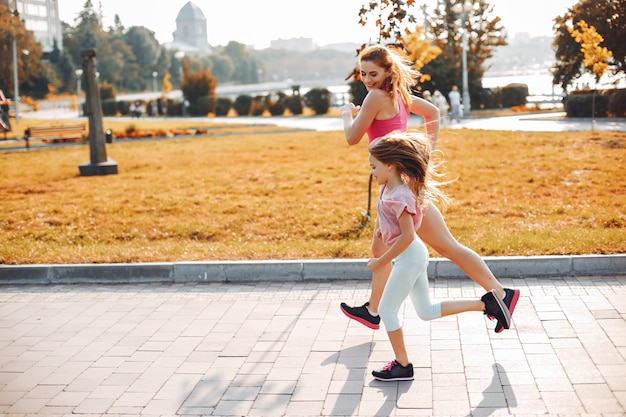 Mother jogging on a tree-lined path with a baby stroller