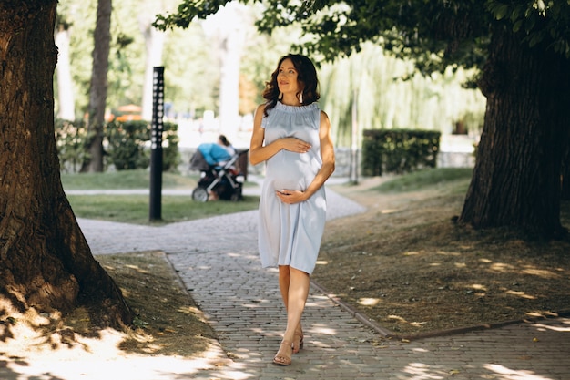 Pregnant woman walking in a park
