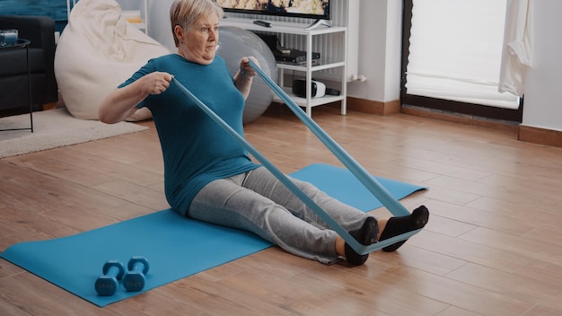 Senior woman using resistance bands at home