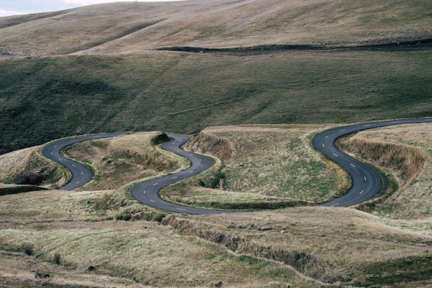 Cyclist transitioning from paved road to mountain trail