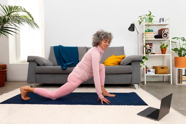 Senior woman performing gentle stretching at home