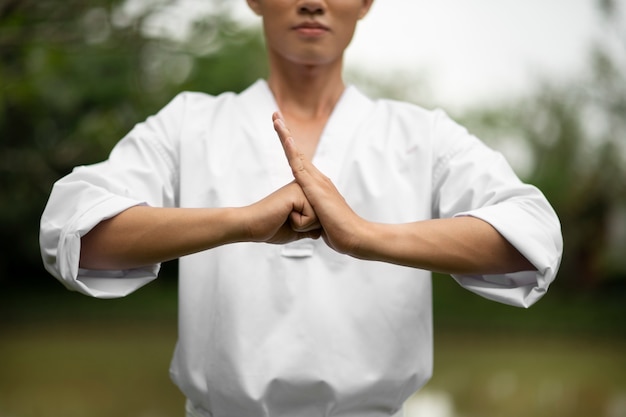 Person practicing Tai Chi in a park for thyroid support