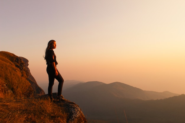 Woman hiking at sunrise with backpack
