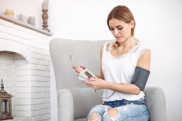 Woman checking blood pressure at home
