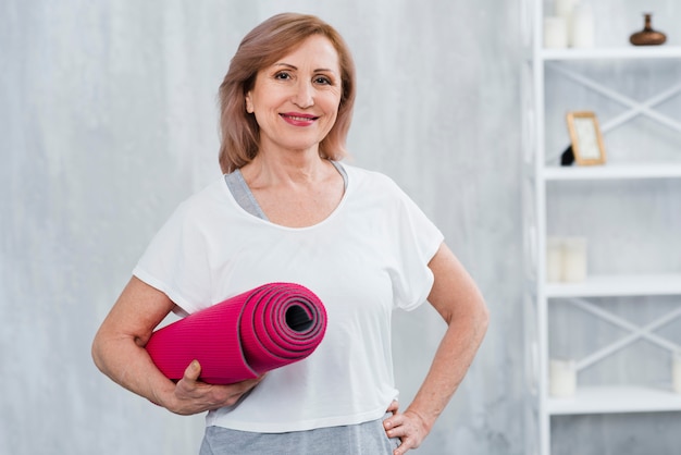 Woman using yoga block and strap during stretch